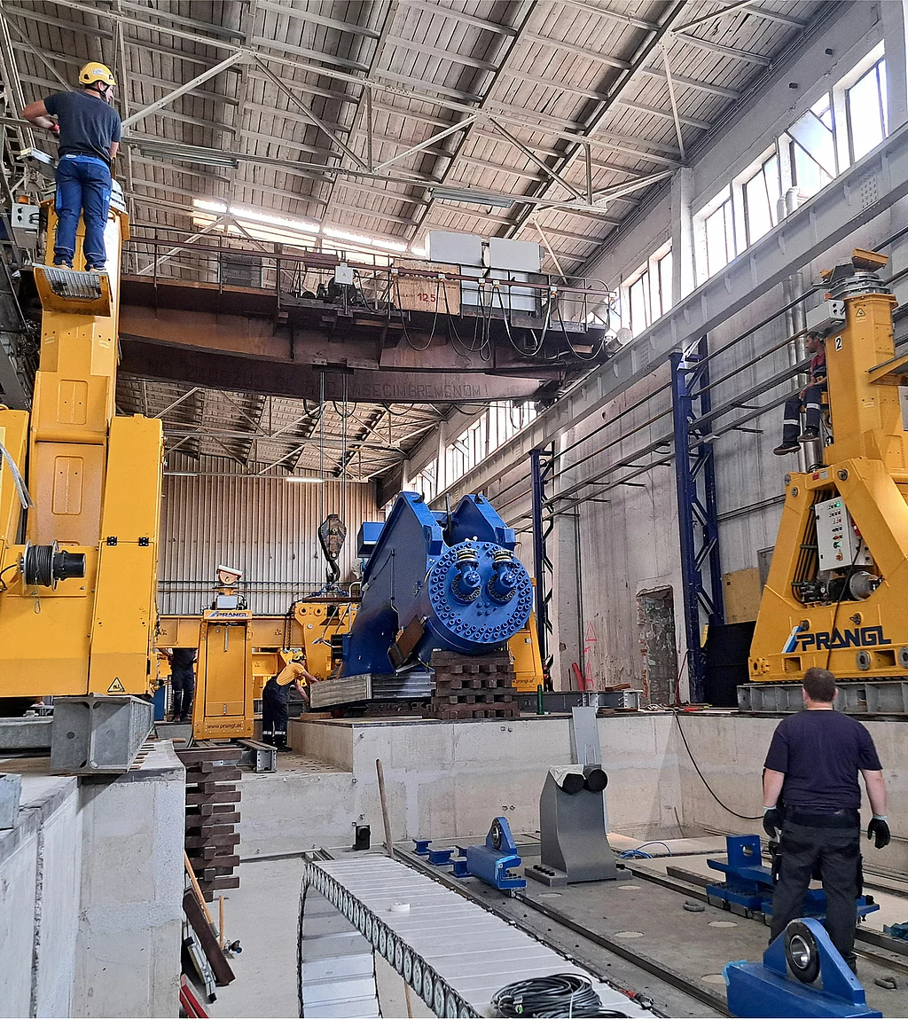 Gesco: Foto: Mitarbeiter montieren Teile der Fahrständerichtanlage 