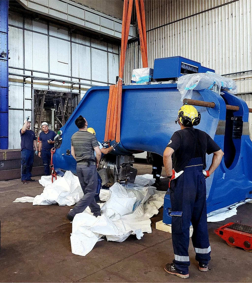 Gesco: Foto: Mitarbeiter installieren die Fahrständerichtanlage mit einer Krananlage